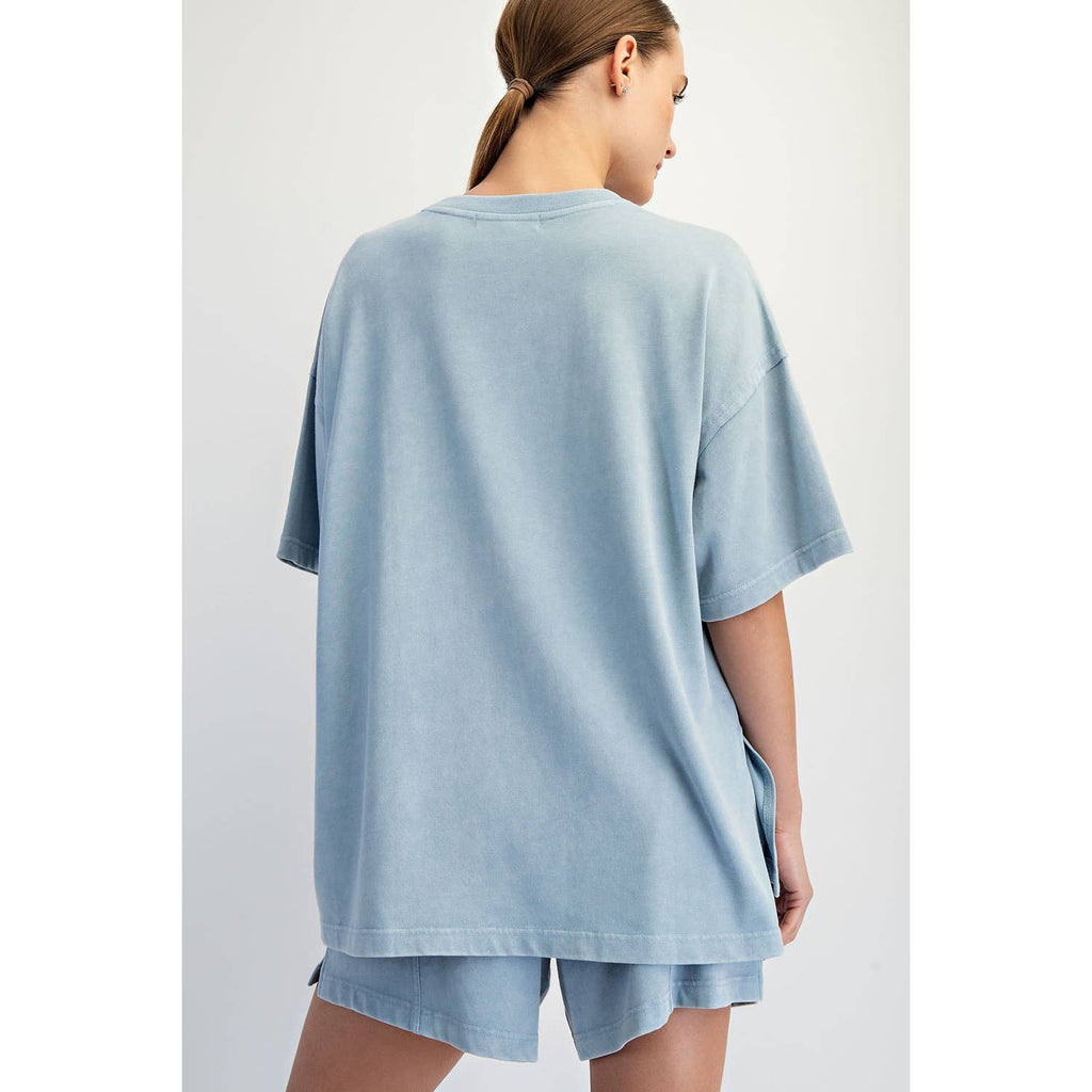Woman wearing a light blue t-shirt and shorts set on a plain background