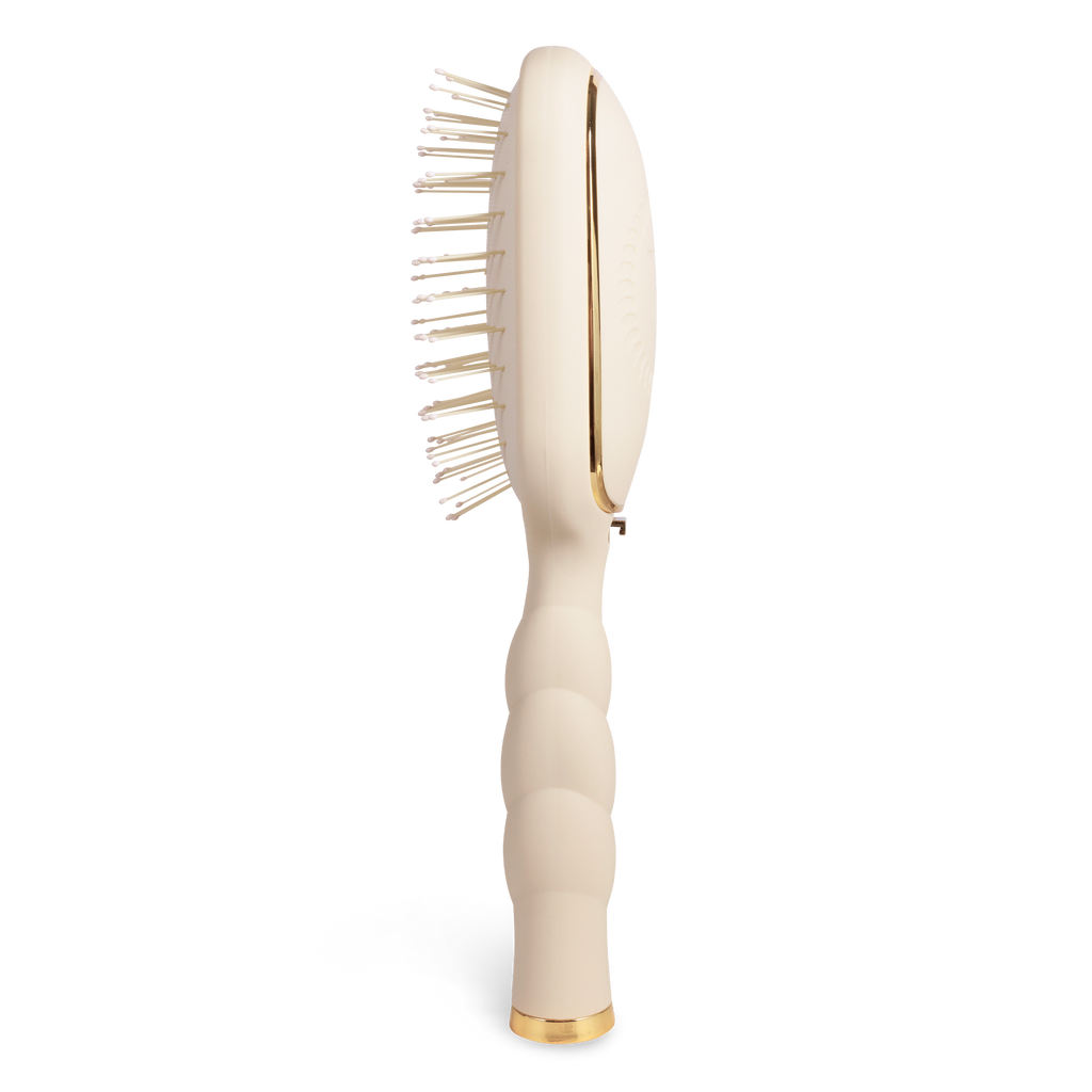 Beige paddle hairbrush with gold accents on a white background