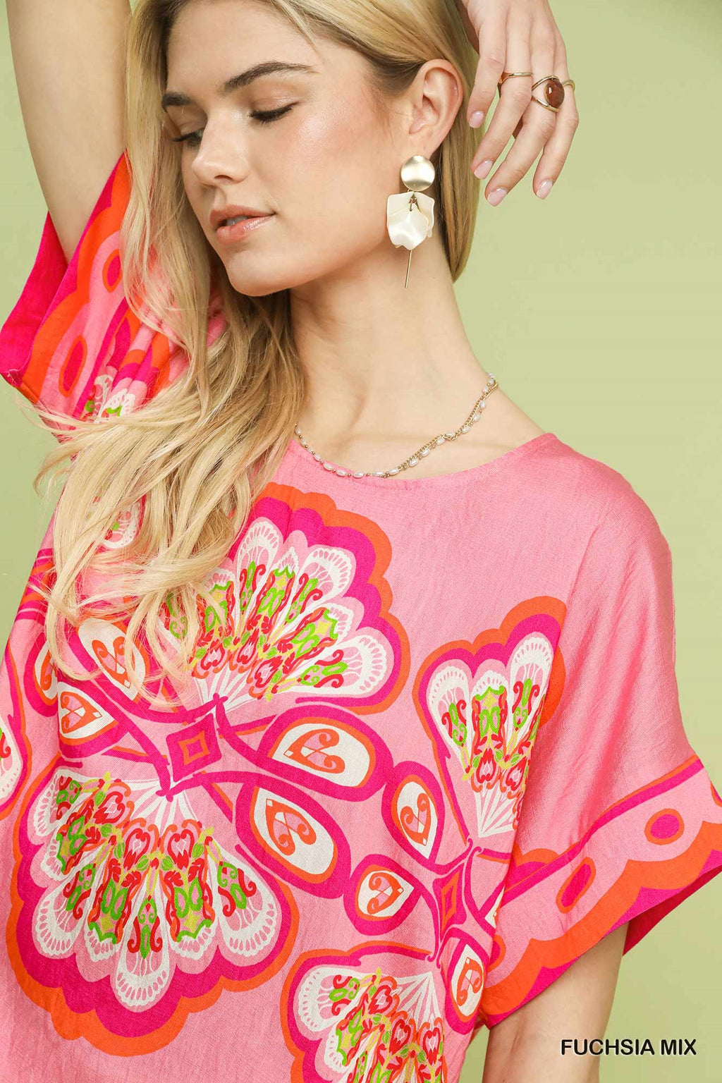 Woman wearing a pink floral blouse with a green background