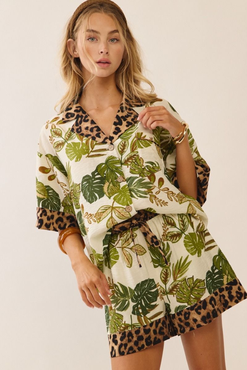 Woman wearing a leaf and leopard print dress on a white background